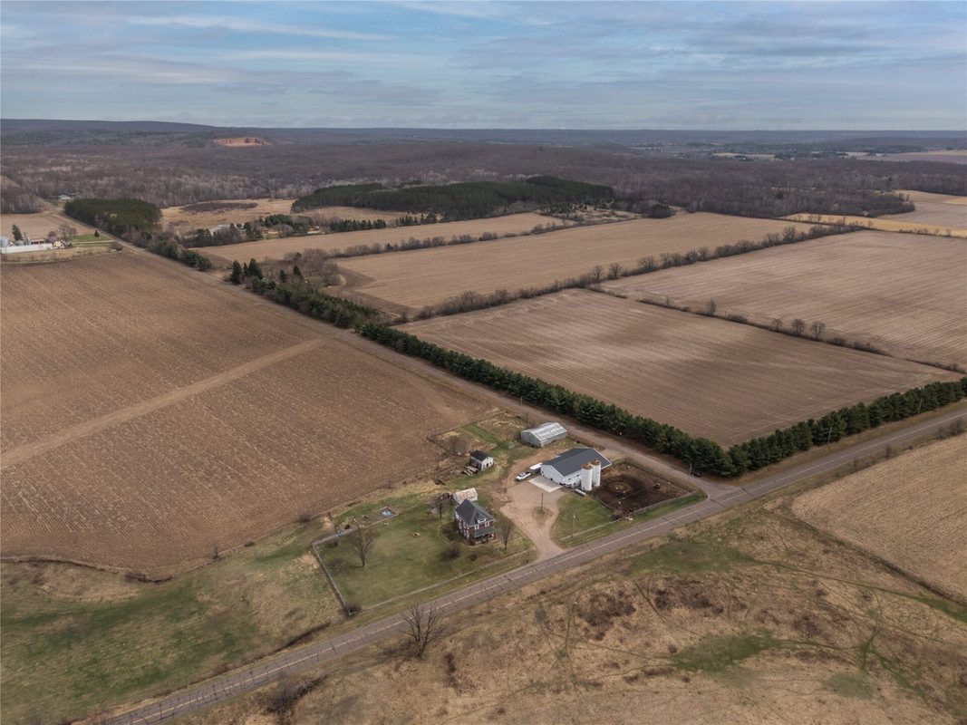 2003 23rd Street, Rice Lake WI 54868 - High aerial of farmstead set within broad harvested crop fields and conifer windbreak boundary - MLS #1598985 - image42
