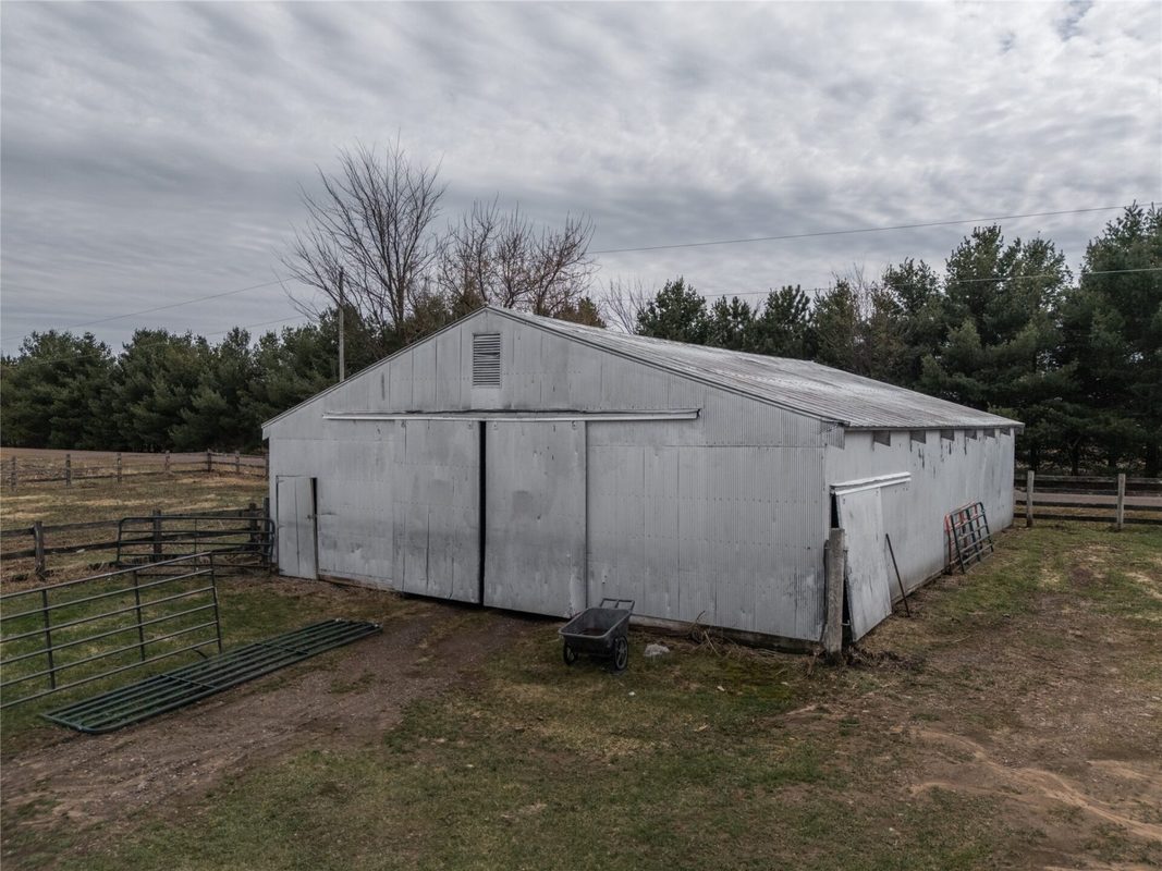 2003 23rd Street, Rice Lake WI 54868 - Older white metal building with sliding double doors and conifer windbreak behind - MLS #1598985 - image35