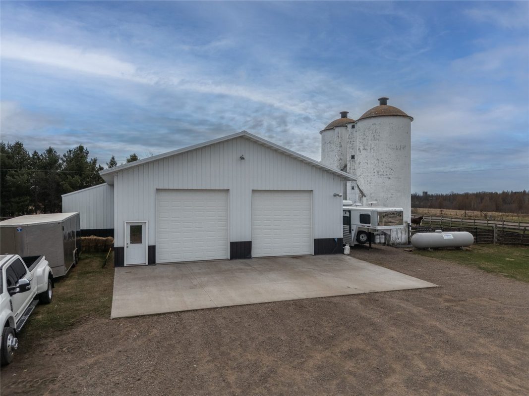 2003 23rd Street, Rice Lake WI 54868 - White metal pole building with two overhead doors, concrete apron, and two silos adjacent - MLS #1598985 - image28
