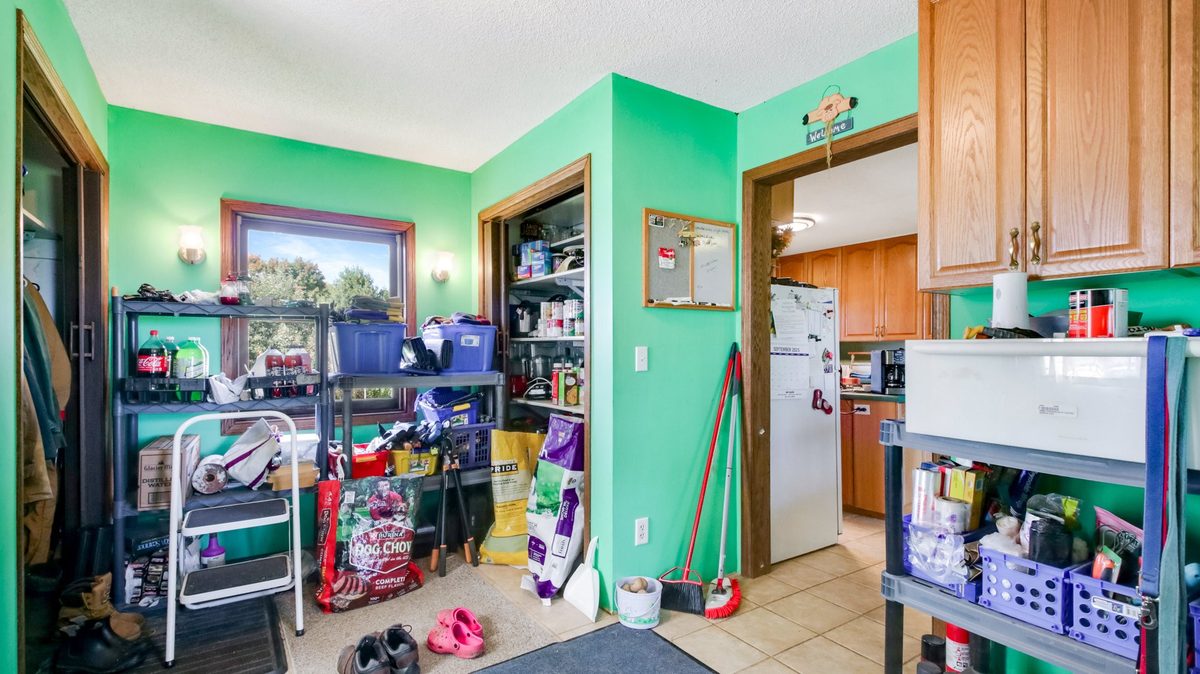 2265 State Highway 87, St Croix Falls WI 54024 - Mudroom with green walls, shelving, pantry closet, and view into kitchen - MLS #1599846 - image11