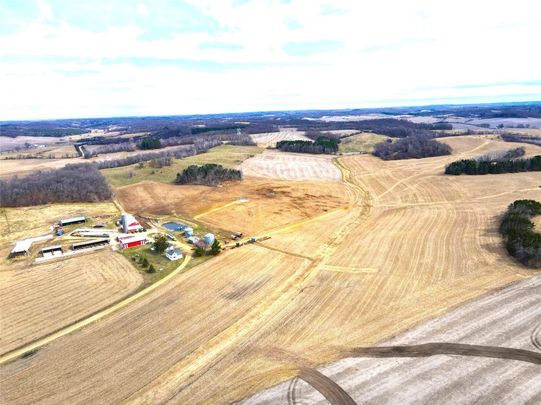 N41286 Halama Road, Independence WI 54747 - Aerial looking across harvested grain fields with farmstead and outbuildings at far left - MLS #1599405 - image9