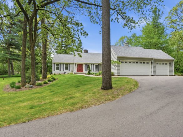 391 Heather Court Eau Claire WI 54701 — front exterior of sage-gray Cape Cod ranch with red door, attached garage, on wooded lot